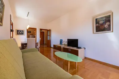 a living room with a couch and a table at Family One bedroom apartment with Panoramic city view in Budva