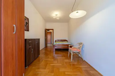 a hallway with a bed and a chair in a room at Family One bedroom apartment with Panoramic city view in Budva