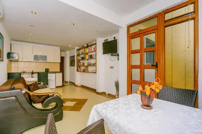 a living room with a table and a kitchen at Apartmani Novaković in Kotor