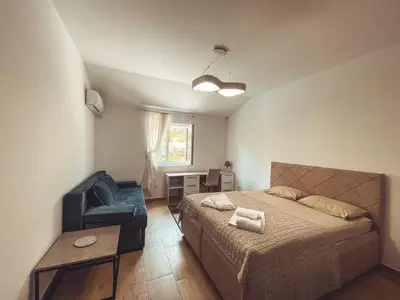 a small bedroom with a bed and a chair at Auto kamp Titograd in Podgorica
