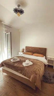 a bedroom with a large bed with two hats on it at Auto kamp Titograd in Podgorica