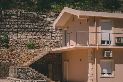 a building with a stone wall and a staircase at Auto kamp Titograd in Podgorica