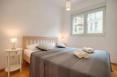 a bedroom with a bed with two towels on it at Aria Apartments in Kotor