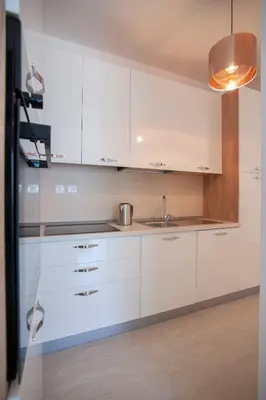a kitchen with white cabinets and a sink at Aria Apartments in Kotor