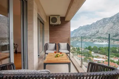 a balcony with a table and chairs and a view at Aria Apartments in Kotor