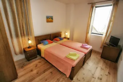 a bedroom with two beds and a television at B&B Apart Hotel Paštrovski Konak in Sveti Stefan