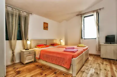 a bedroom with a bed and a television in it at B&B Apart Hotel Paštrovski Konak in Sveti Stefan