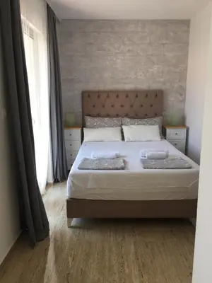 a bedroom with a bed and a brick wall at Soheds in Budva