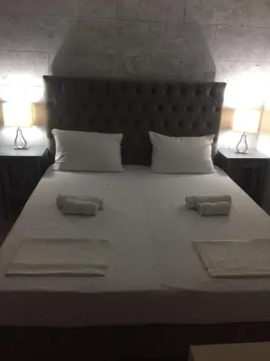 a bedroom with a large bed with two towels on it at Soheds in Budva
