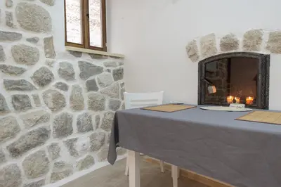 a table in a room with a stone wall at Kotor Bagus - Cozy Boutique Old Town Studio with Seaview Terrace in Kotor