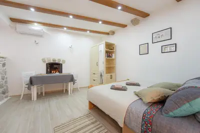 a bedroom with a bed and a desk and a fireplace at Kotor Bagus - Cozy Boutique Old Town Studio with Seaview Terrace in Kotor