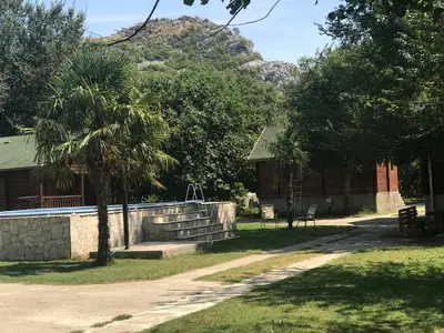 a building with a palm tree next to a road at Wooden Village Resort in Ponari