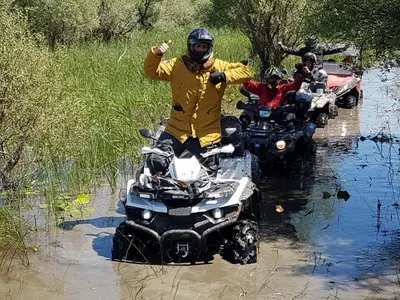 a group of people riding atvs in the water at Wooden Village Resort in Ponari