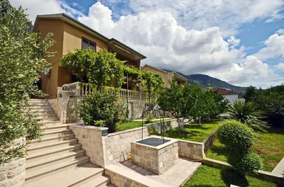 a house with stairs and trees in the yard at Apartmani Ćetković in Kotor