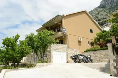 a motorcycle parked in front of a building with a garage at Apartmani Ćetković in Kotor