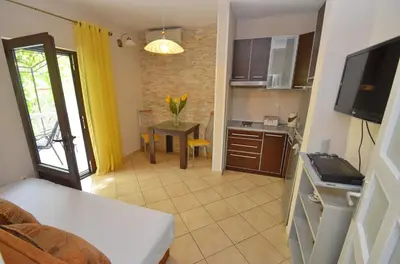 a room with a kitchen with a table and a kitchen at Apartmani Ćetković in Kotor