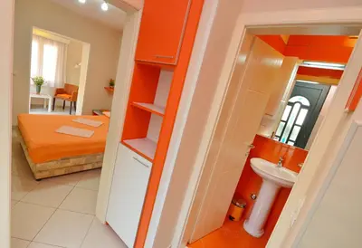 a small room with a bed and a sink at Apartmani Ćetković in Kotor