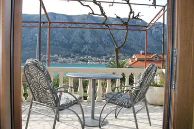 a table and two chairs on a balcony with a view at Apartmani Ćetković in Kotor