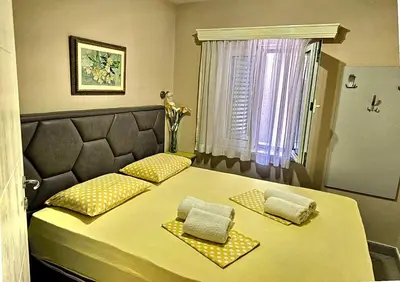 a bedroom with a bed with two pillows on it at Apartmani Ćetković in Kotor