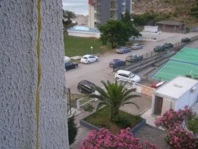 a view of a parking lot with cars and a tennis court at Aleksandar in Sutomore