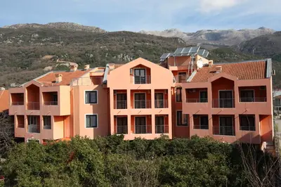 a building on a hill with mountains in the background at Guesthouse Orlović in Budva