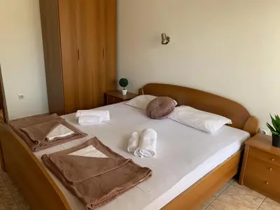 a bed with two towels and slippers on it at Guesthouse Orlović in Budva