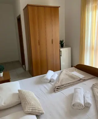 a bedroom with a white bed with towels on it at Guesthouse Orlović in Budva