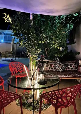 a table and chairs with a tree on a patio at Accommodation Royal Azur in Dobra Voda
