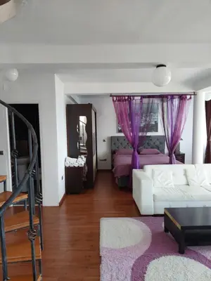 a living room with a white couch and purple curtains at Accommodation Royal Azur in Dobra Voda