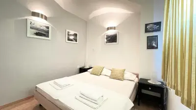 a small bedroom with a bed and some pictures on the wall at Apartments Antonela in Sveti Stefan