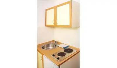 a small kitchen with a sink and a cabinet at Apartments Antonela in Sveti Stefan