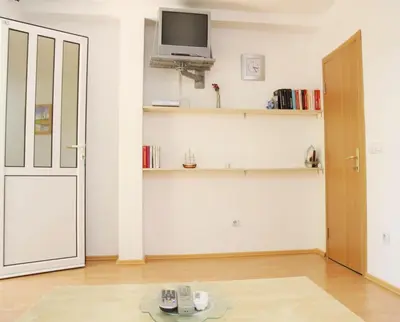 a room with a door and a tv on a wall at Apartments Antonela in Sveti Stefan
