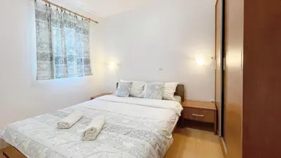a bedroom with a bed with two white towels on it at Apartments Antonela in Sveti Stefan