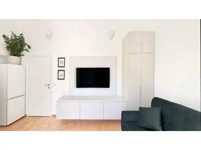 a living room with a couch and a flat screen tv at Apartments Antonela in Sveti Stefan