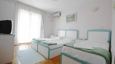 a room with two beds and a television in it at Apartments Miković in Budva