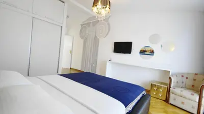 a bedroom with a bed and a tv and a chair at Apartments Miković in Budva