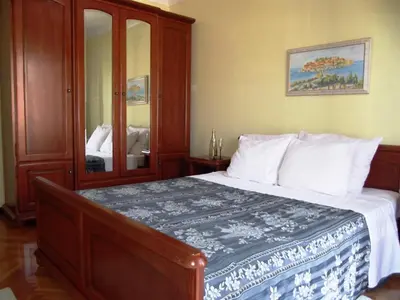 a bedroom with a large bed with a mirror at Apartments Miković in Budva
