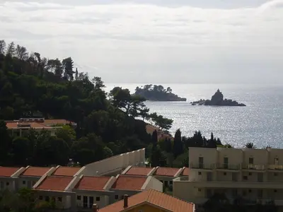 a view of the ocean with houses and an island at Apartments Pod Lozom with Seaview in Petrovac na Moru