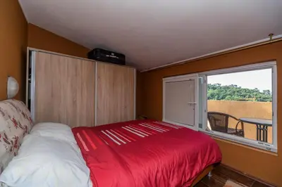 a bedroom with a red bed and a window at Apartments Pod Lozom with Seaview in Petrovac na Moru
