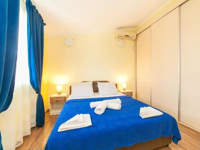 a bedroom with a blue bed with towels on it at Apartments Midžor in Petrovac na Moru