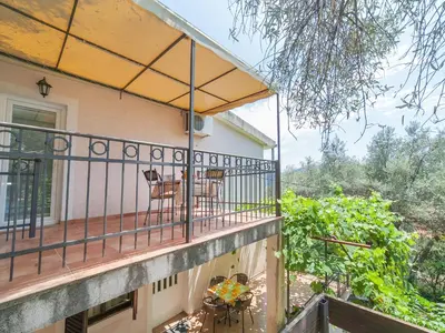 a balcony of a house with a table and chairs at Apartments Midžor in Petrovac na Moru