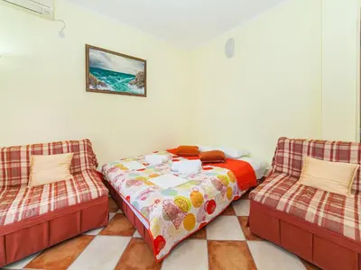a bedroom with two beds and two chairs at Apartments Midžor in Petrovac na Moru