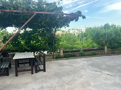 two benches sitting under a canopy in a park at Apartmani Joca in Sutomore