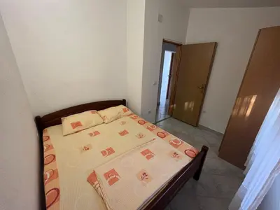 a bedroom with a bed with a bedspread and pillows at Apartmani Joca in Sutomore