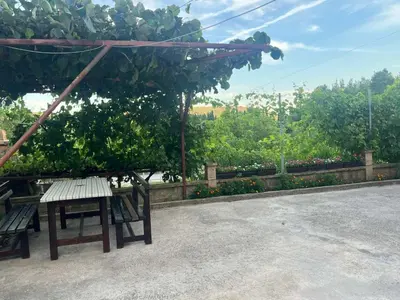 a bench sitting under a canopy in a park at Apartmani Joca in Sutomore