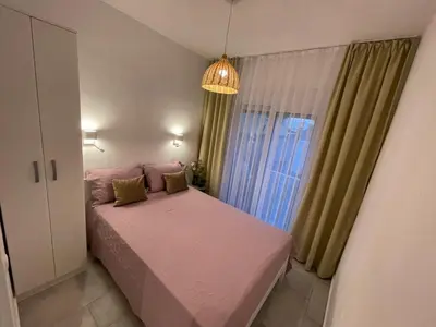 a small bedroom with a pink bed and a window at Villa Hanna in Ulcinj