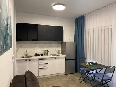 a kitchen with a sink and a table with chairs at Villa Hanna in Ulcinj