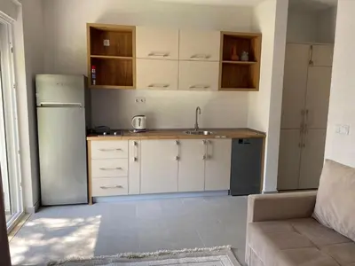 a kitchen with white cabinets and a sink and a refrigerator at Villa Hanna in Ulcinj