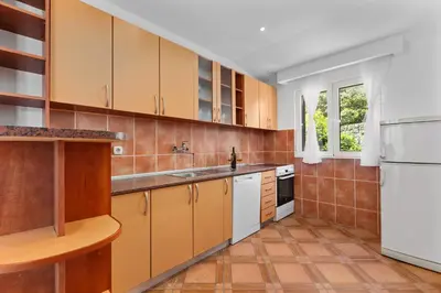a kitchen with yellow cabinets and a white refrigerator at Apartments Dončić in Kotor