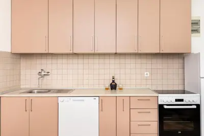 a kitchen with white cabinets and a sink at Apartments Dončić in Kotor